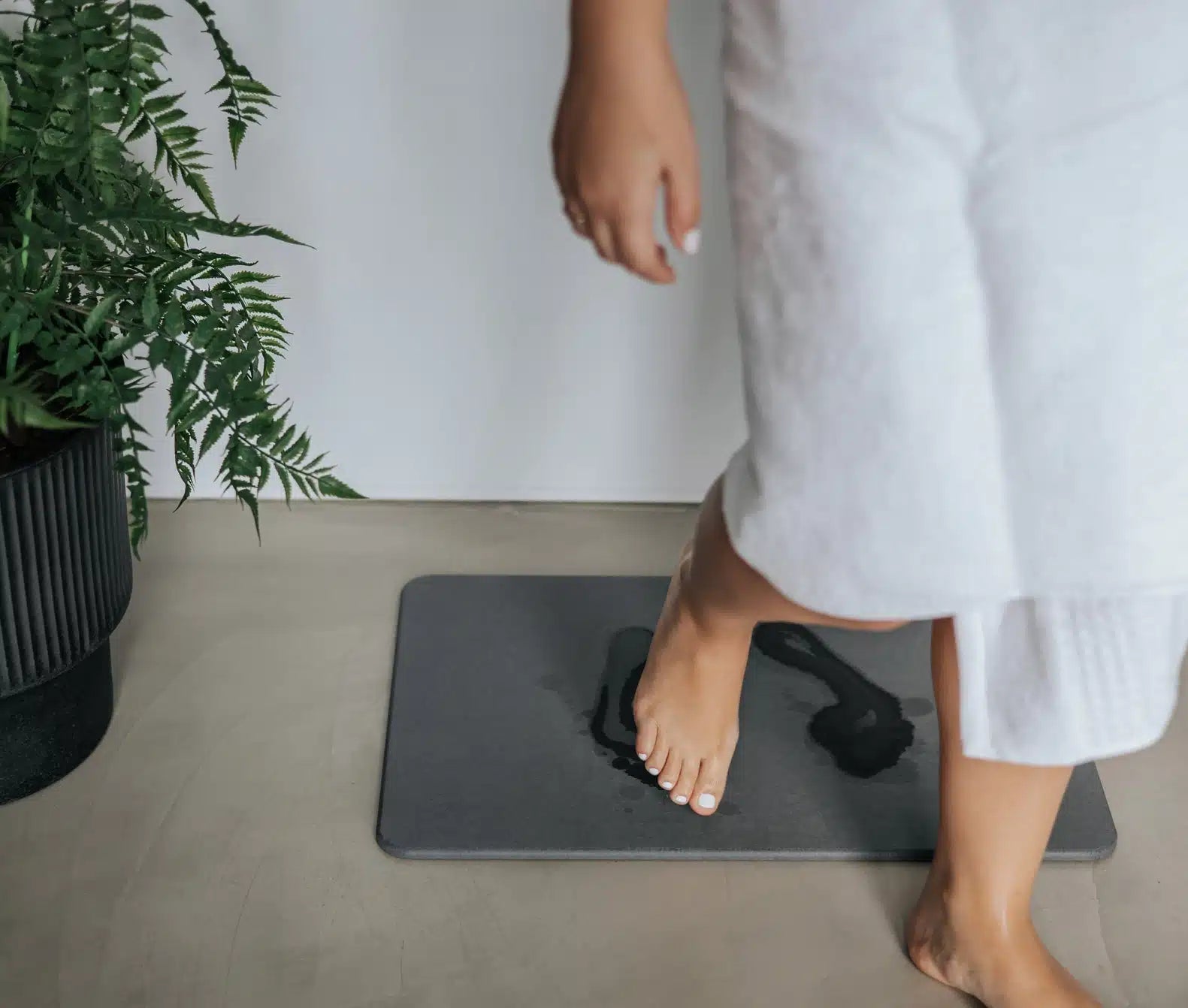 Bare feet stepping onto a diatomite bath stone